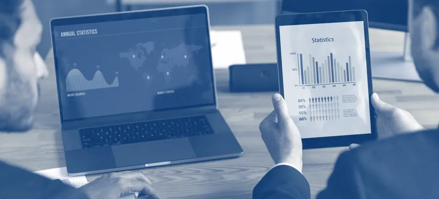 Dupla de profissionais analisando gráficos e indicadores em laptop e tablet — representa o diagnóstico financeiro e o business intelligence da consultoria Prosperium